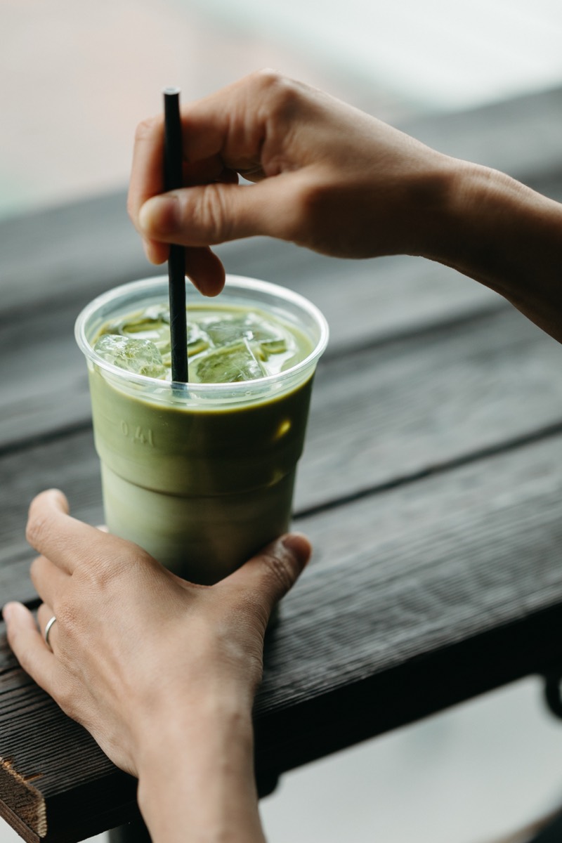 Hands holding a Kawa Musubi iced matcha latte
